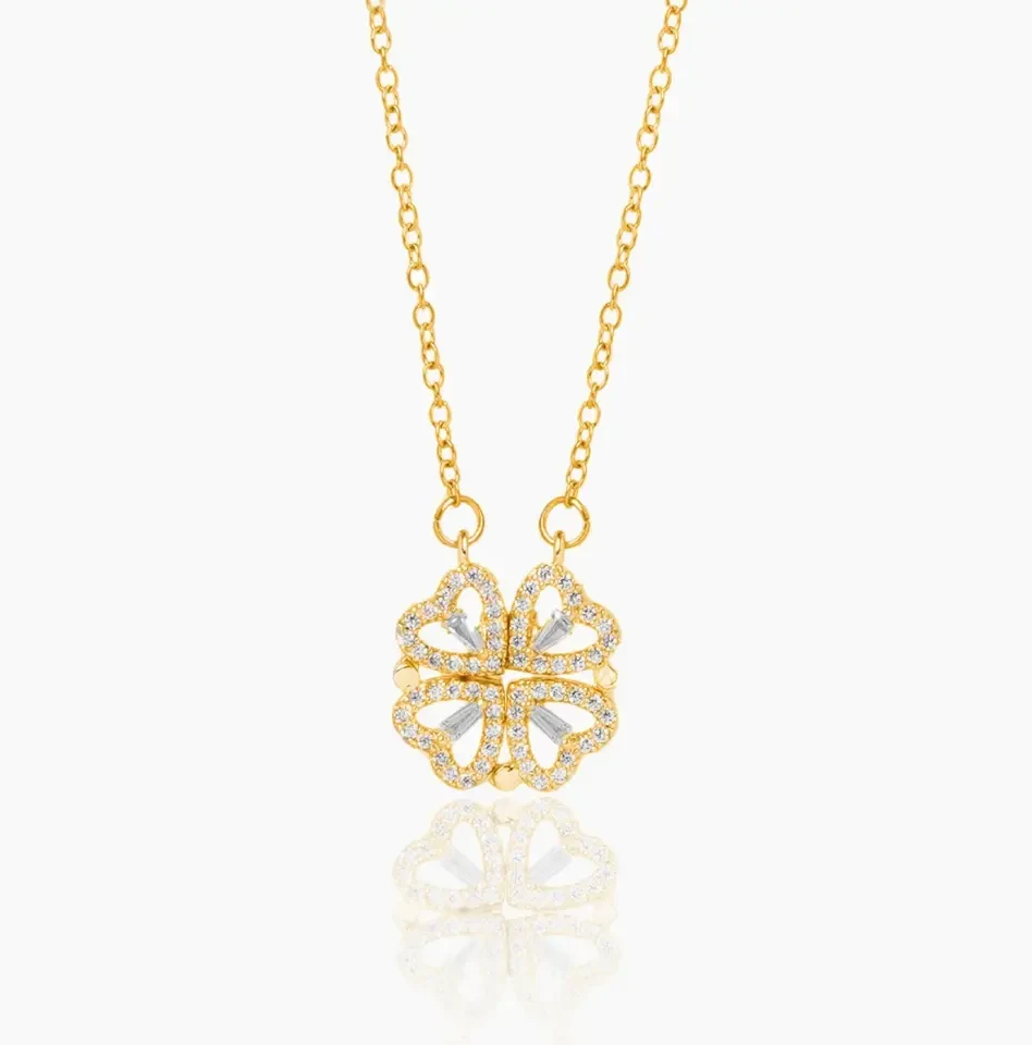 Gold clover necklace with four pavé heart leaves snapped together into a clover
